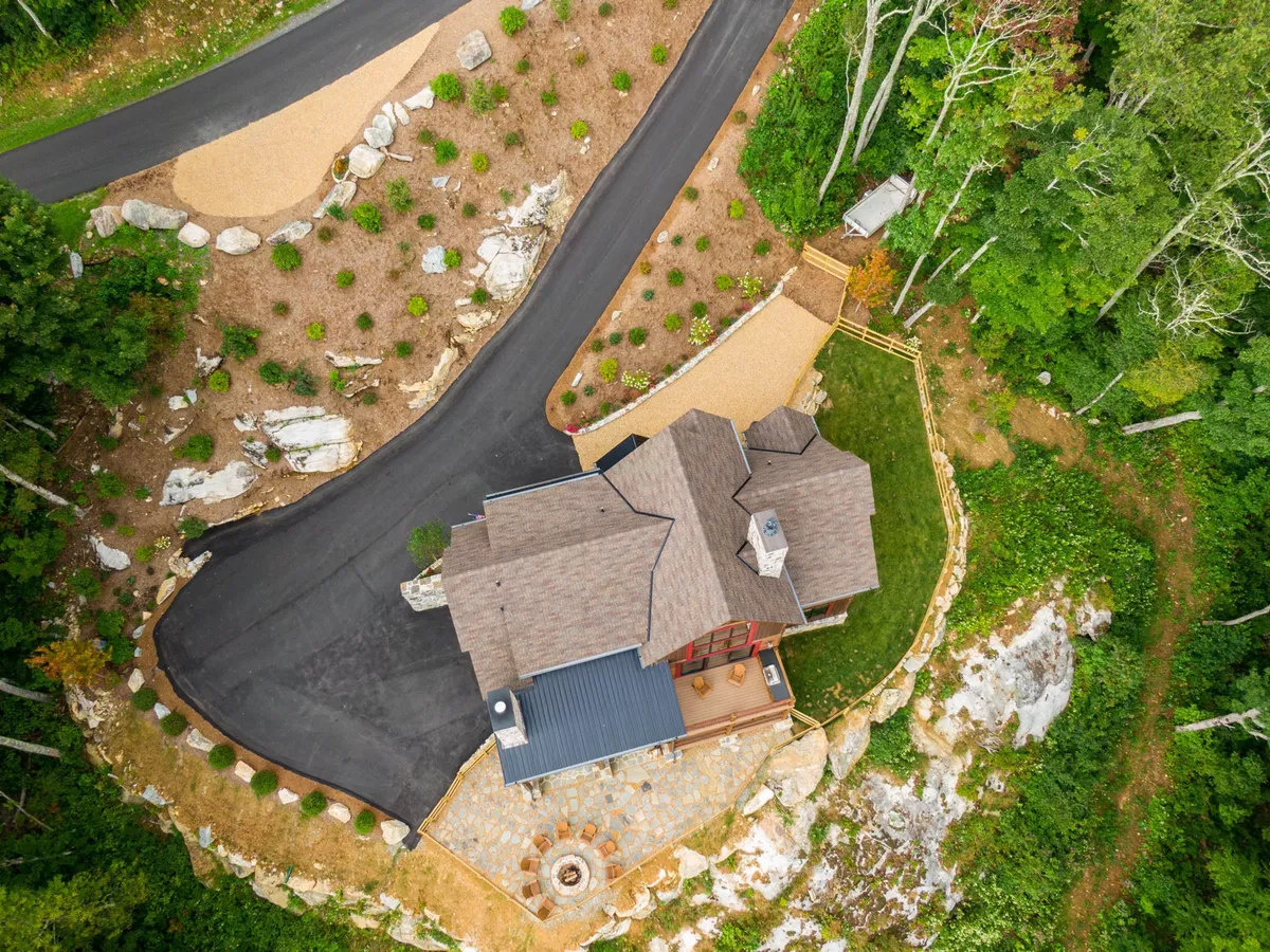 This image captures the exterior of Majestic View Hideaway, featuring the house set against landscaped gardens, a winding driveway, and natural rock formations. The scene is peaceful yet inviting, hinting at the outdoor experiences awaiting just beyond the doorstep.