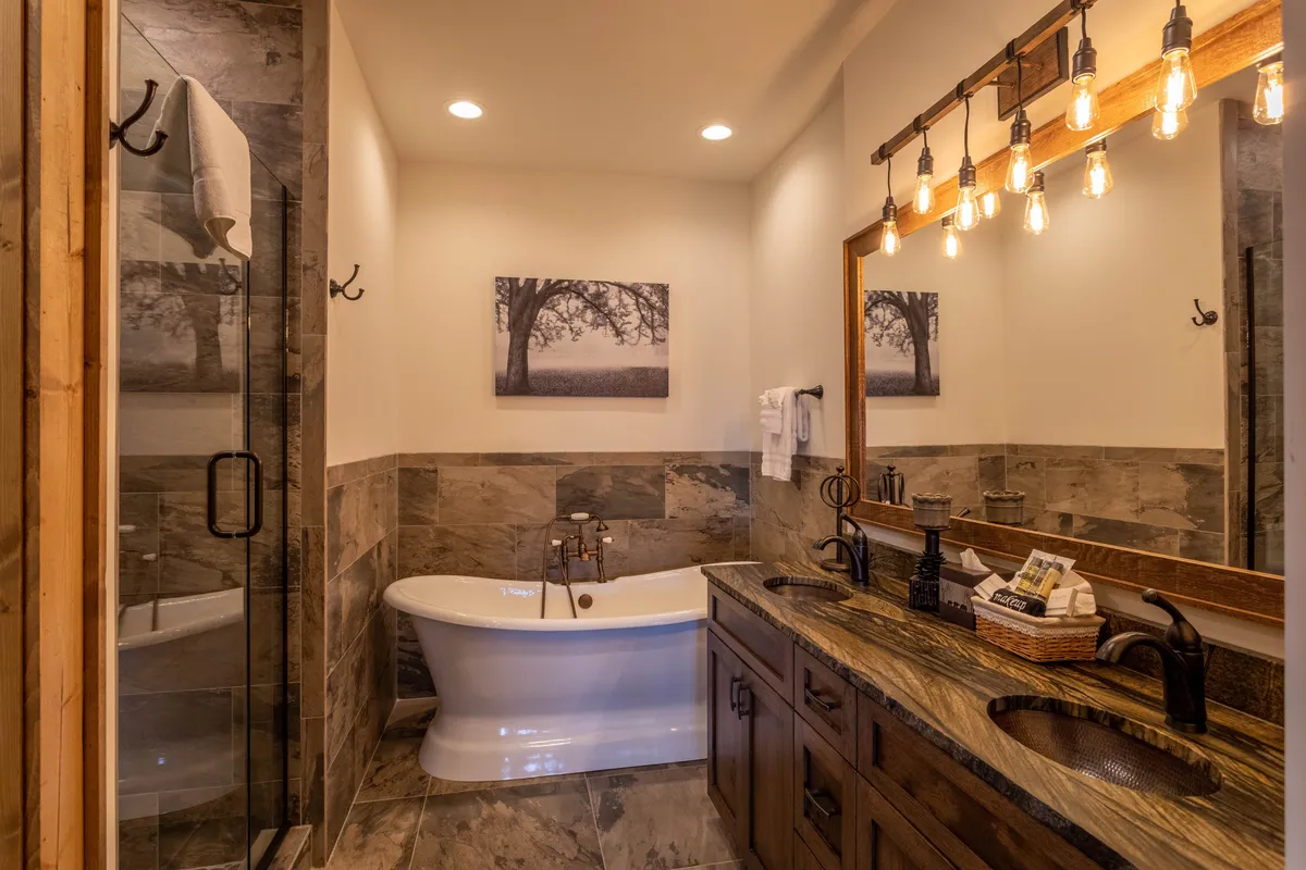 A modern, calming bathroom with a freestanding soaking tub, elegant wooden vanity, and decorative lighting. The ambiance is soothing, inviting relaxation and self-care after a busy day.